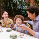 Happy family dining at a kid-friendly restaurant in Orlando with outdoor seating and playground in 2025