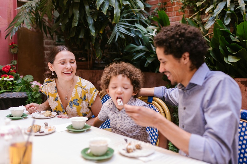 Happy family dining at a kid-friendly restaurant in Orlando with outdoor seating and playground in 2025