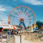 Visitors enjoying rides at an Orlando theme park with discount tickets in 2025