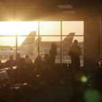 Travelers checking airport signs at Orlando airport comparing MCO and SFB options