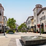 Outdoor Orlando outlet shopping mall with designer stores, trees, and a central fountain